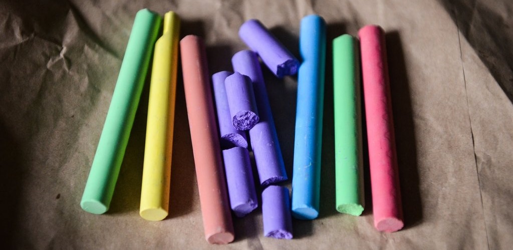 A collection of crayons in different colours. Two purple ones are broken.