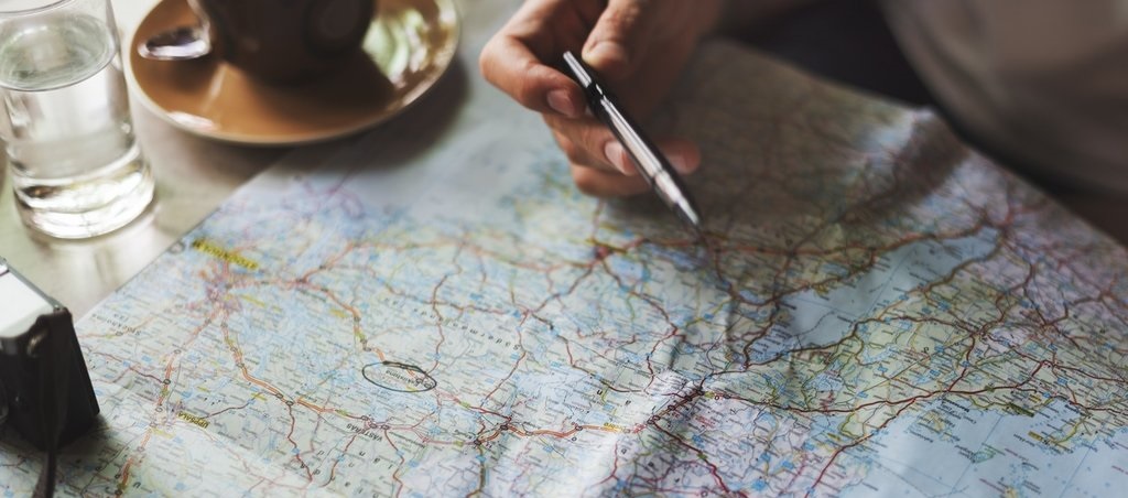 Map with hand pen pointing towards target