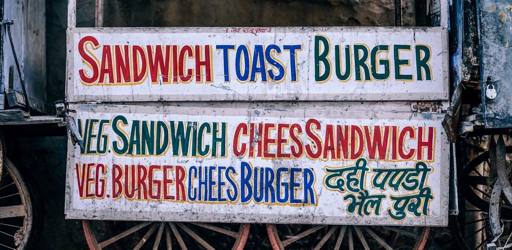 A sign that reads 'Sandwich, toast, burger. Veg. Sandwich , Chees Sandwich, Veg. Burger, Chees Burger